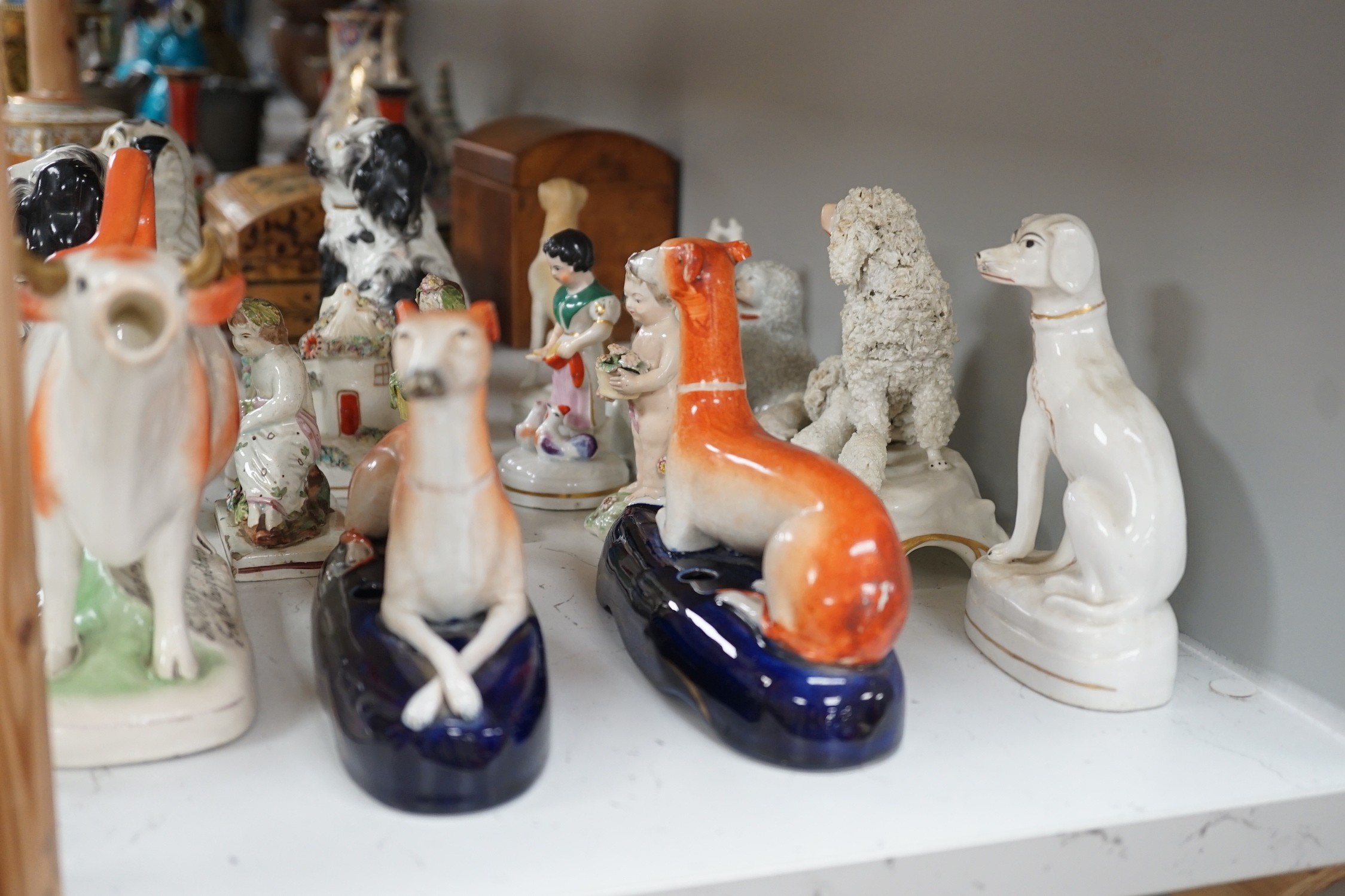 A quantity of Victorian Staffordshire animal figures, two pearlware putti and a Derby figure of a cherub, tallest 14.5 cm